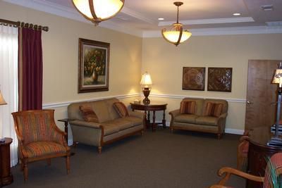 A living room with a couch , chairs and lamps