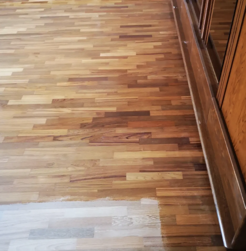 Pavimento in legno con una leggera zona levigata vicino a una fila di armadietti sulla destra.