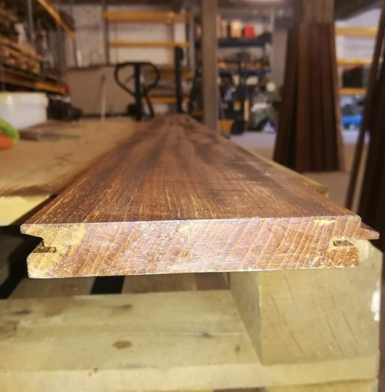Primo piano di una tavola di legno con la superficie superiore rifinita in un'officina.