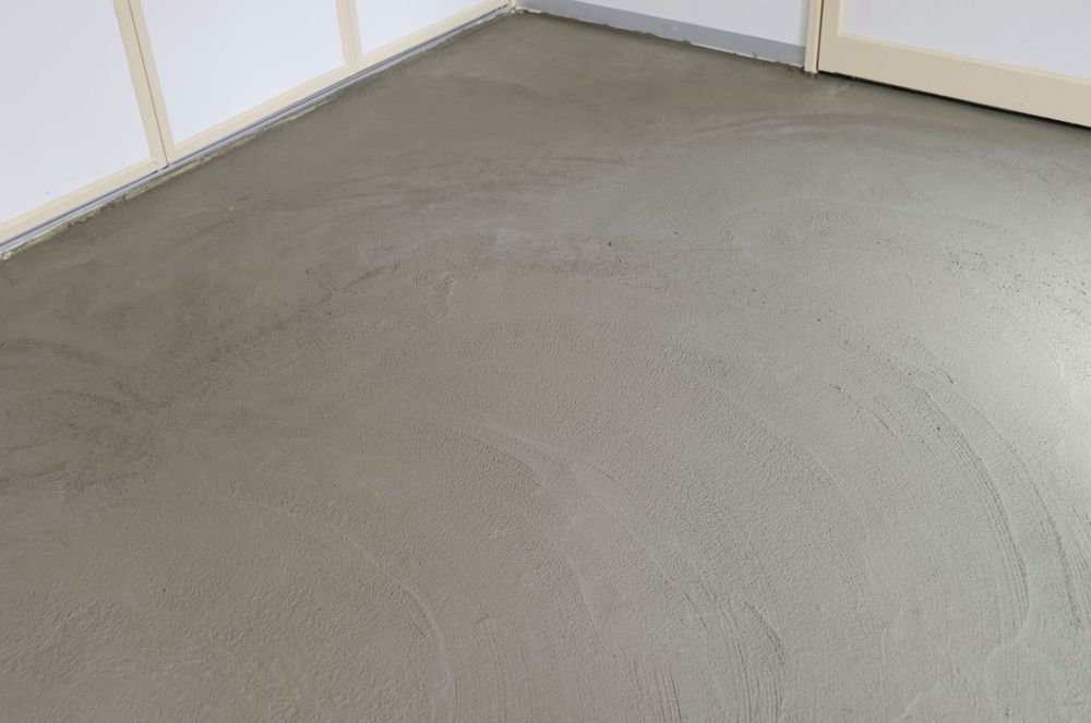 Angolo di stanza vuoto con moquette, pavimento grigio chiaro e pareti bianche