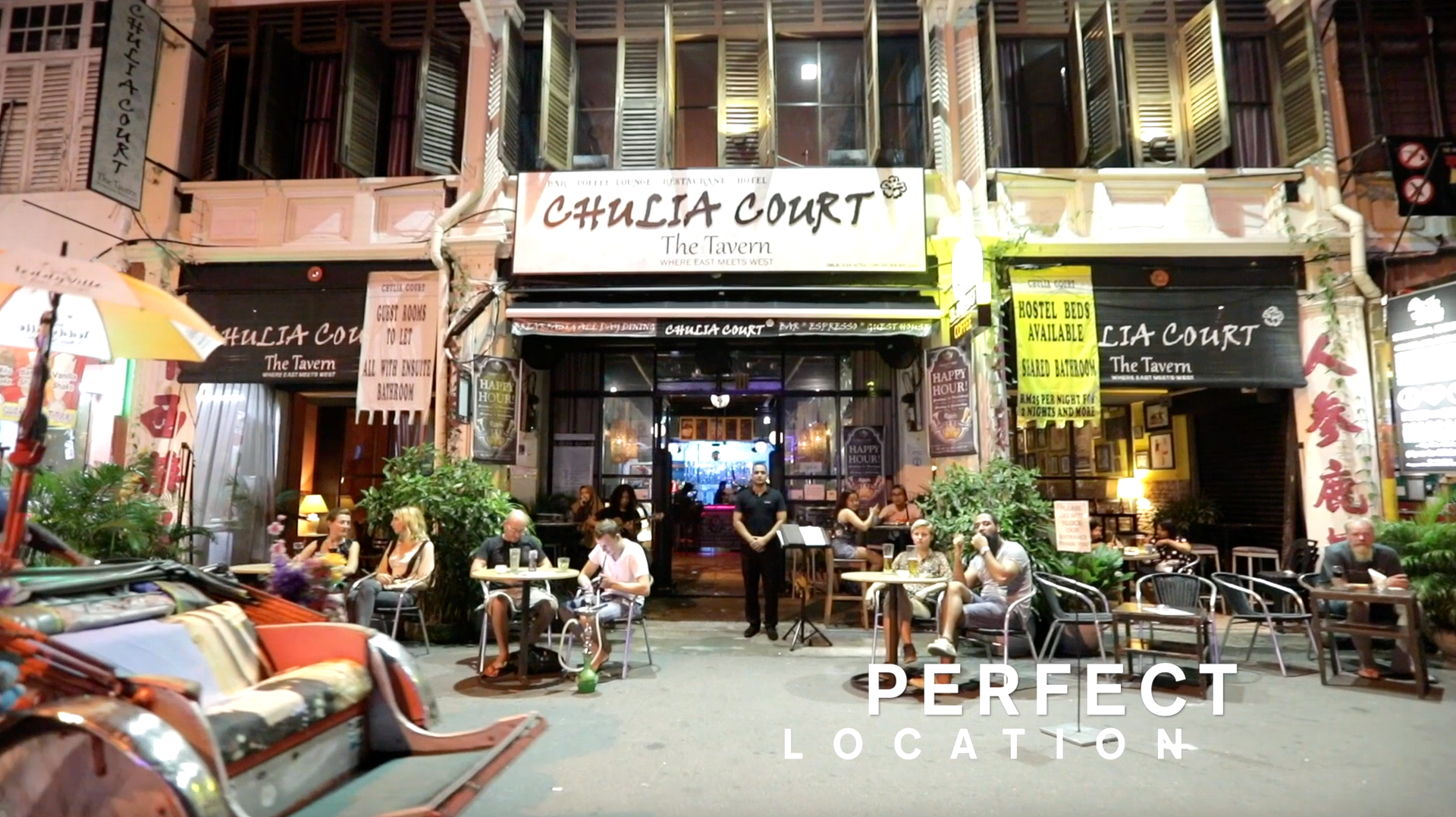Busy street-front café at night with outdoor seating at Chulia Court