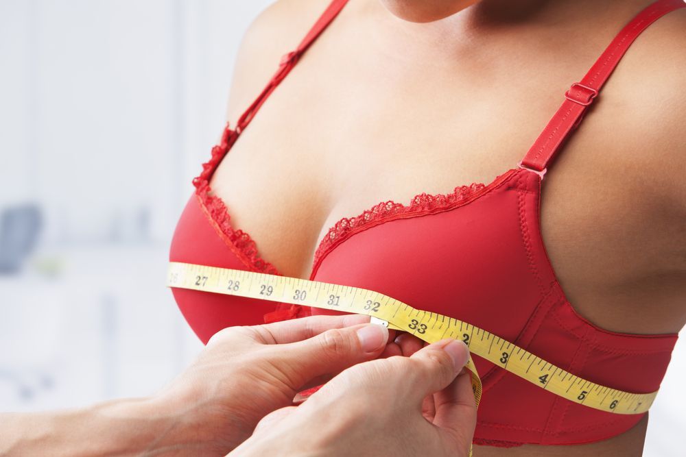 Person's Chest Wearing a Red Bra Being Measured — Shona's Lingerie in Hermit Park, QLD