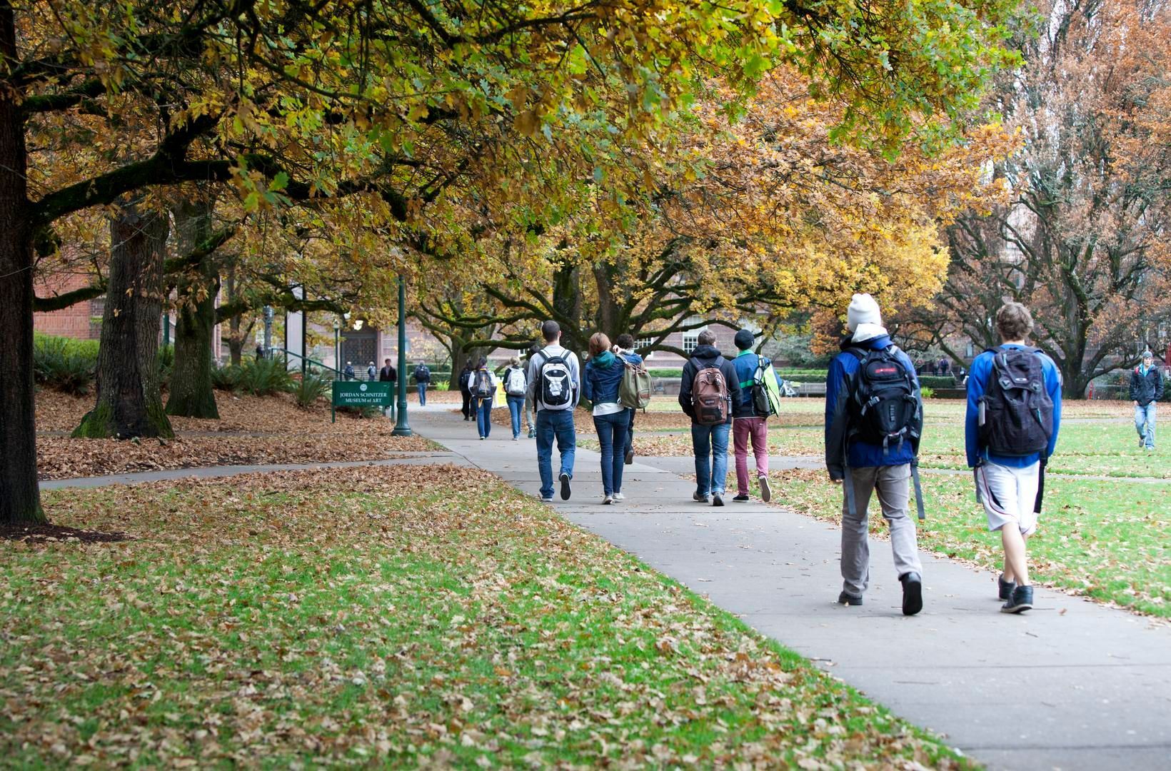 University of Oregon students walking on campus amidst fall trees