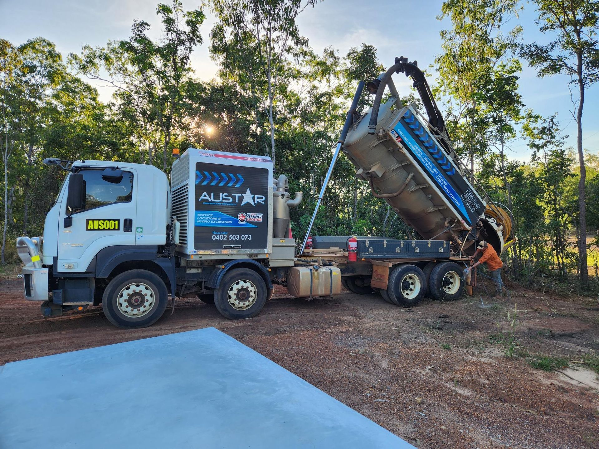A Vacuum Truck is Parked in a Dirt Lot With Trees in the Background — Austar Underground Services in Girraween, NT