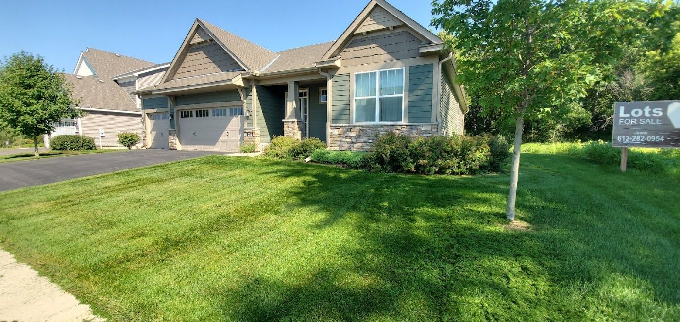A house with a green lawn. There is a sign in the front yard.