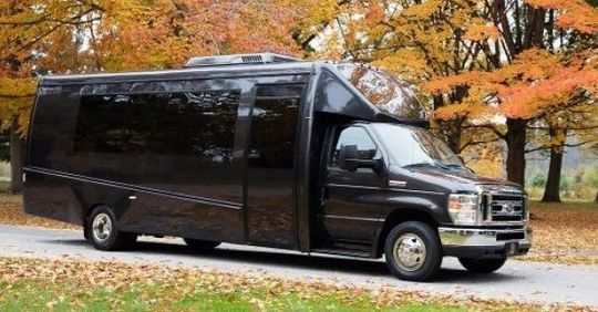 A black van is parked on the side of a road.