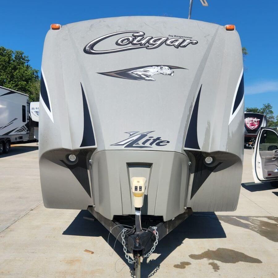 A cougar lite trailer is parked in a parking lot