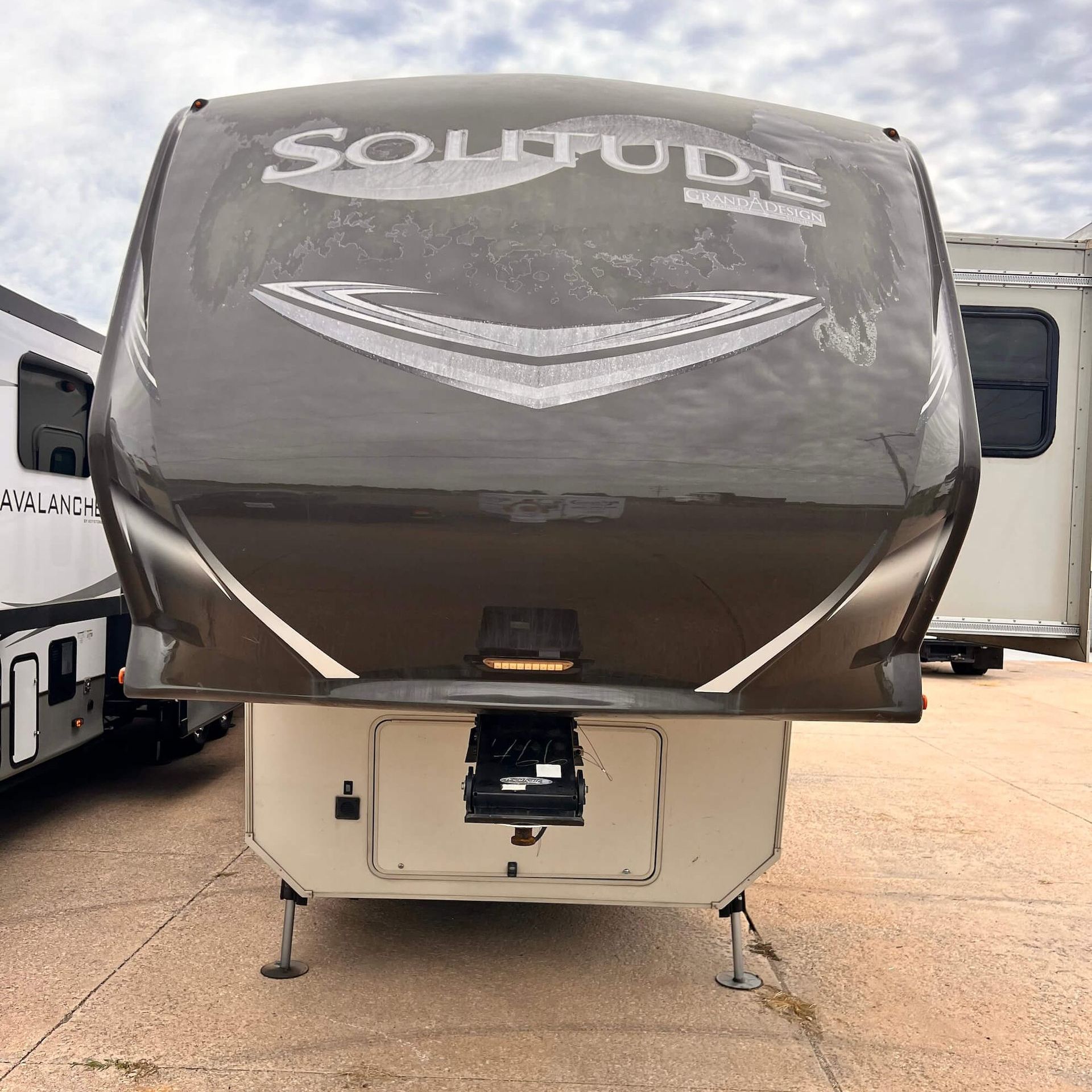 A black solitude trailer is parked in a parking lot