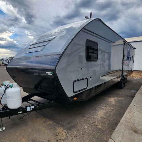 A trailer is parked in a parking lot next to a building.