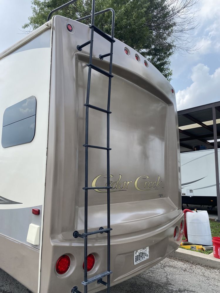 A ladder is attached to the back of a camper