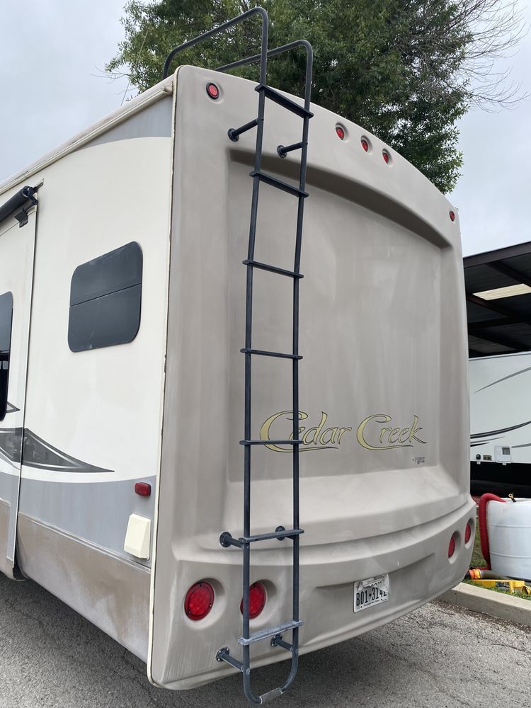 The back of a camper with a ladder attached to it