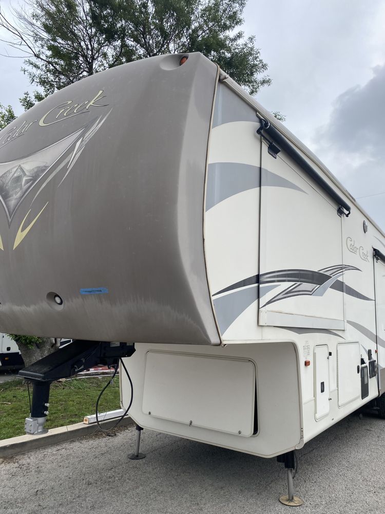A white rv is parked on the side of the road.