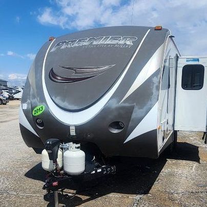 A grey and white rv is parked in a parking lot.