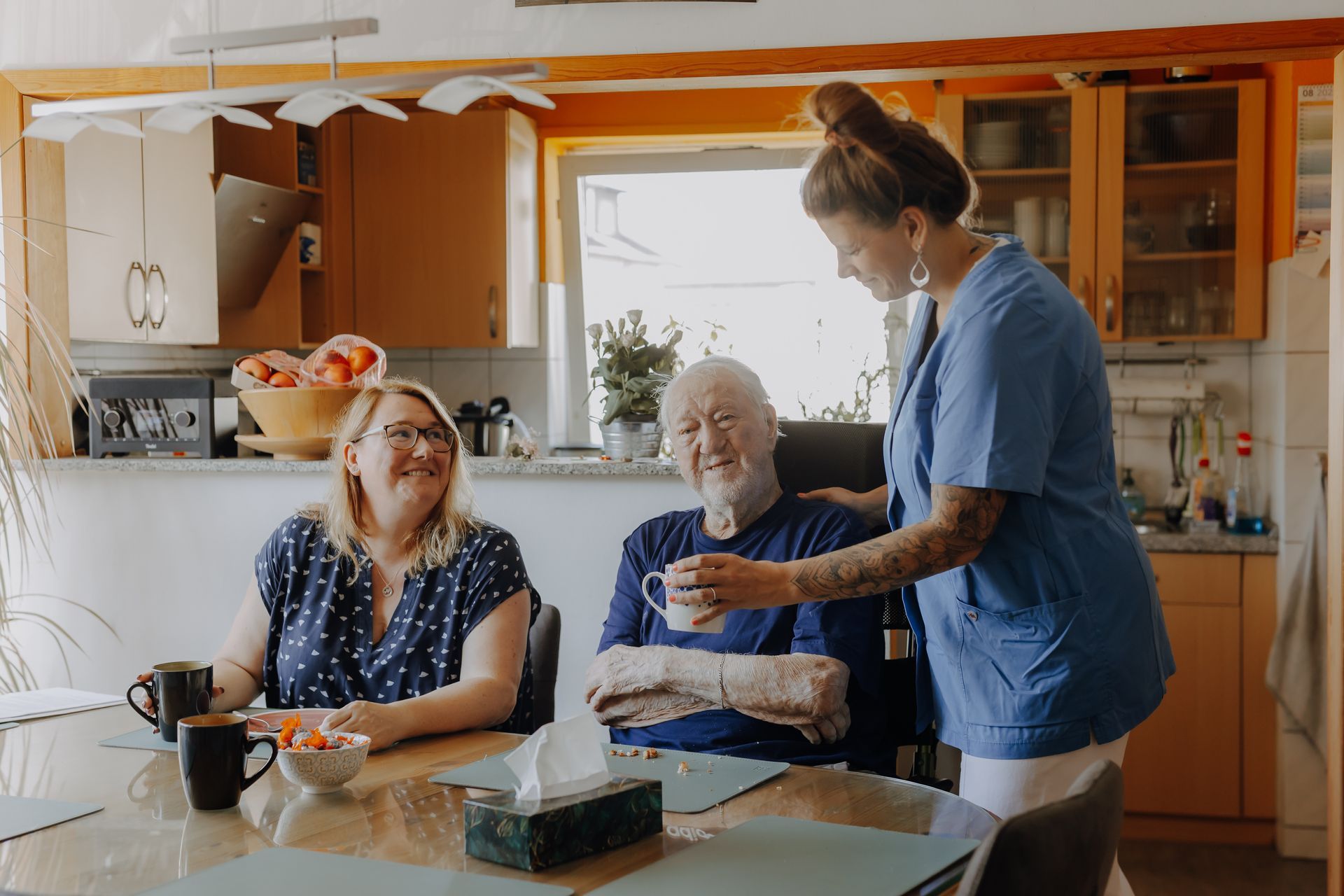 Pflegende Angehörige helfen pflegebedürftiger Person vom Bett aufzustehen.