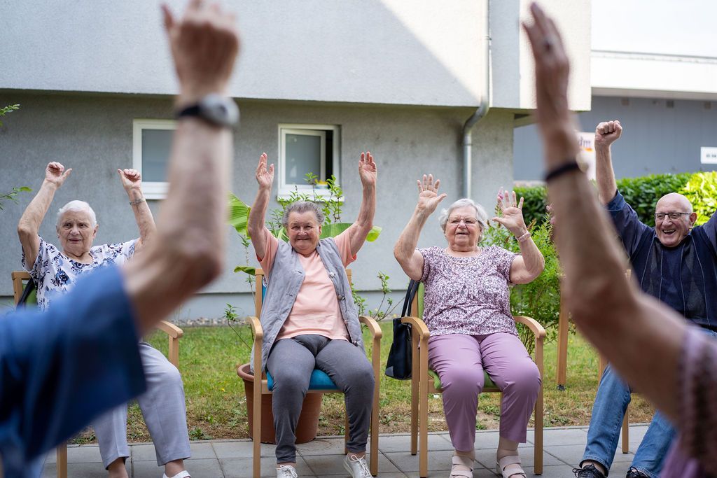 Gäste der Tagespflege St. Elisabeth Bühl machen Gymnastik im Garten.