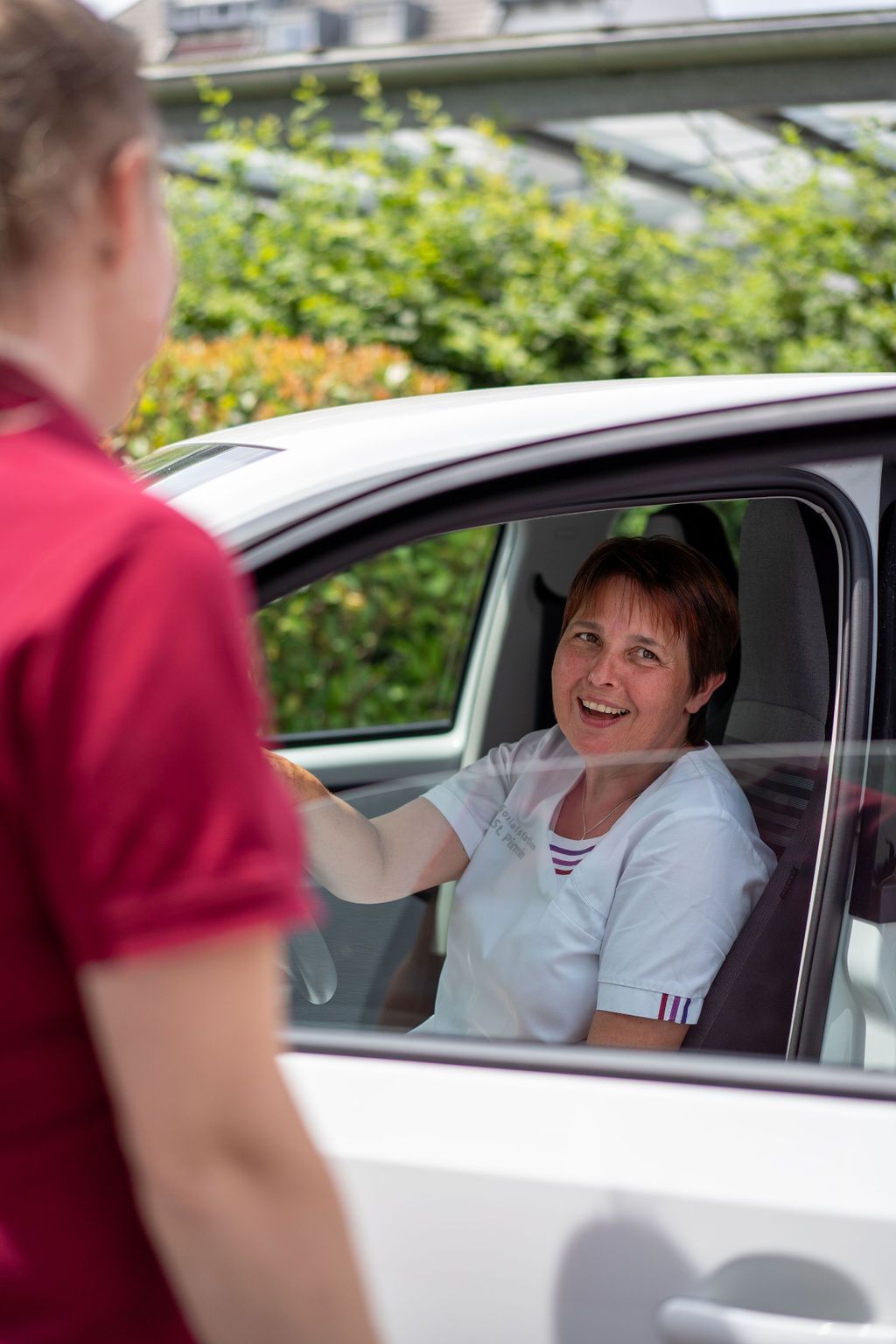 Pflegefachkraft am Steuer eines Dienstwagens