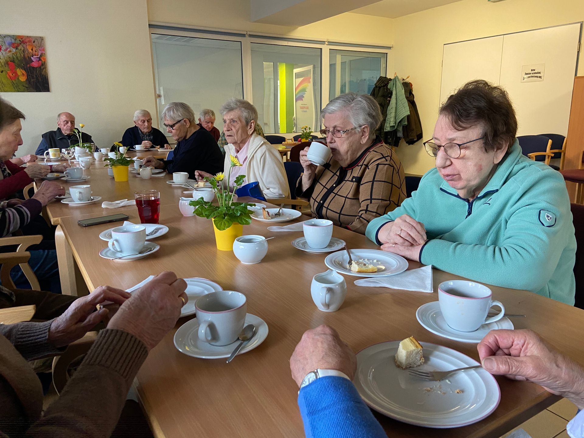 Senioren sitzen am Tisch bei Kaffee und Kuchen in unserem Betreuungscafe Elli