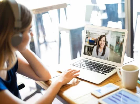 Woman with headphones on a video call with another woman