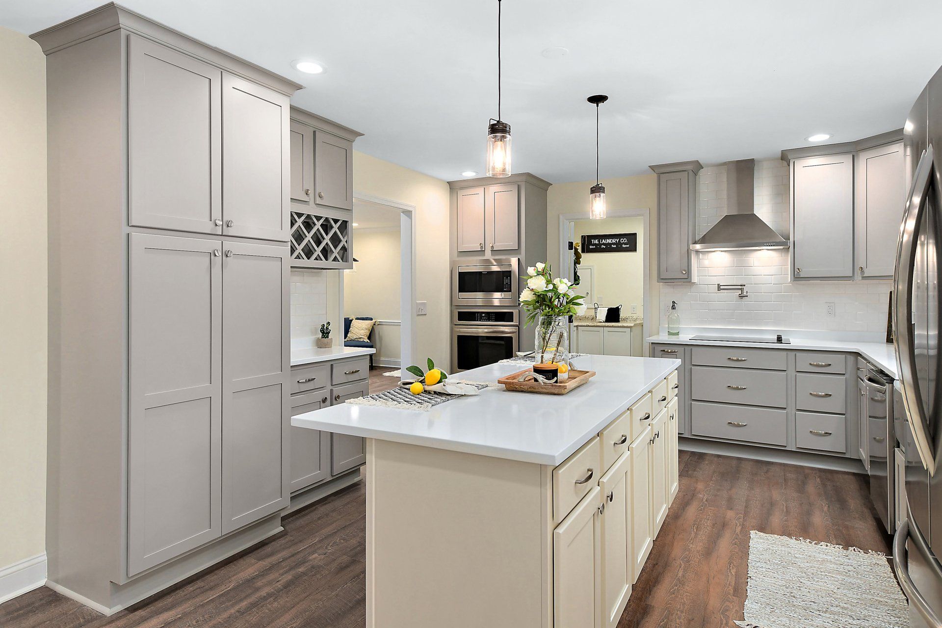Gray and white kitchen with island, cabinets, and stainless steel appliances.