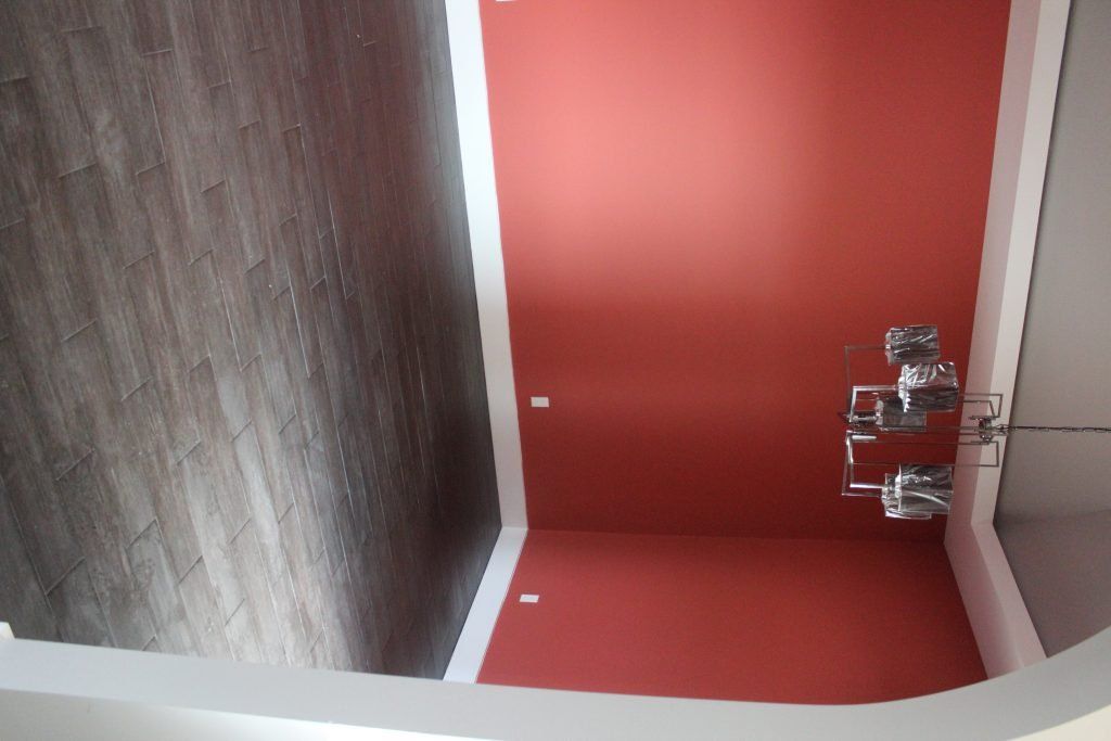 Ceiling with red paint and wood paneling, a light fixture, and white trim.