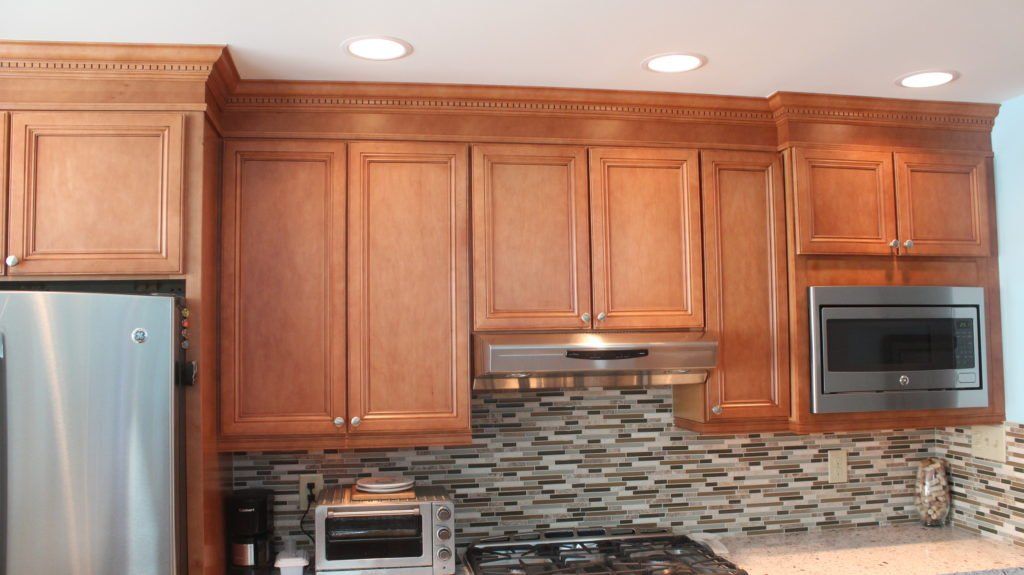 Kitchen with light-brown cabinets, stainless steel appliances, and a mosaic tile backsplash.