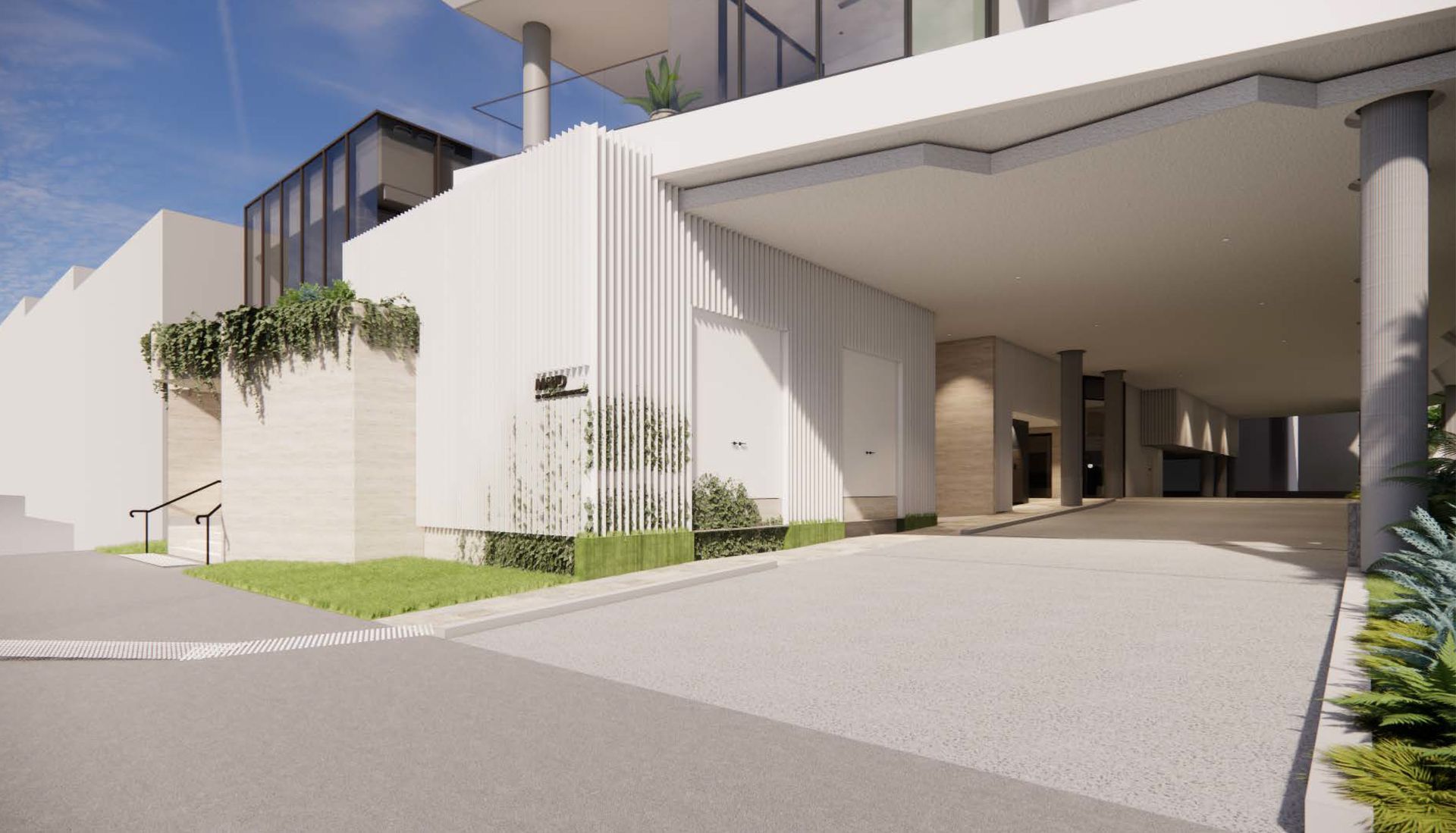 Modern white building entrance with ramp, columns, and greenery.