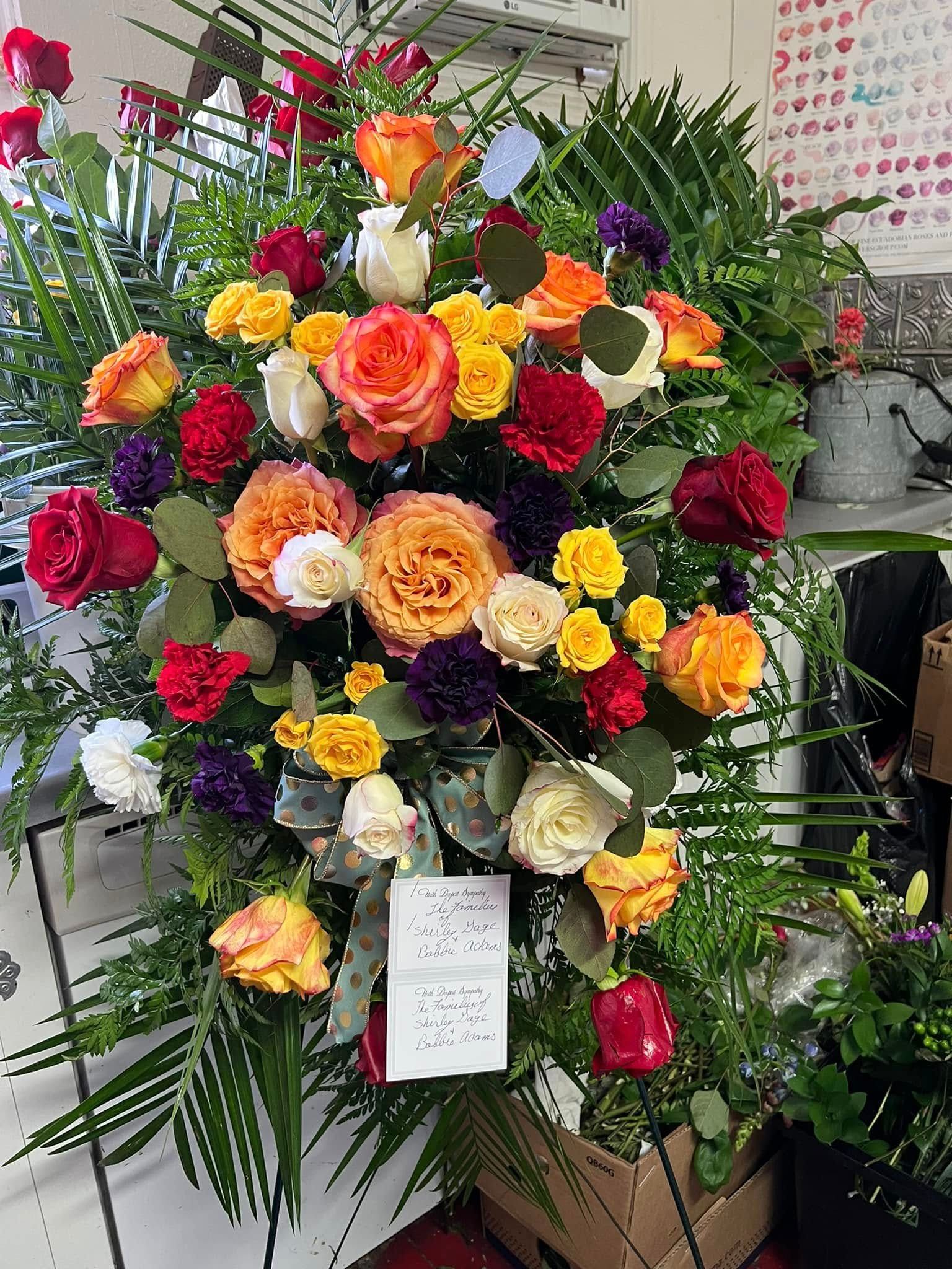 Colorful flower arrangement with roses and greenery.