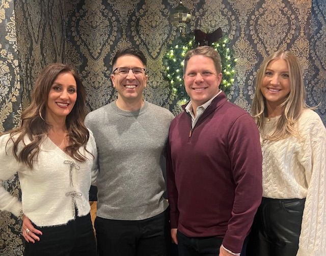 Brick building with large windows and a flat roof under a partly cloudy sky.