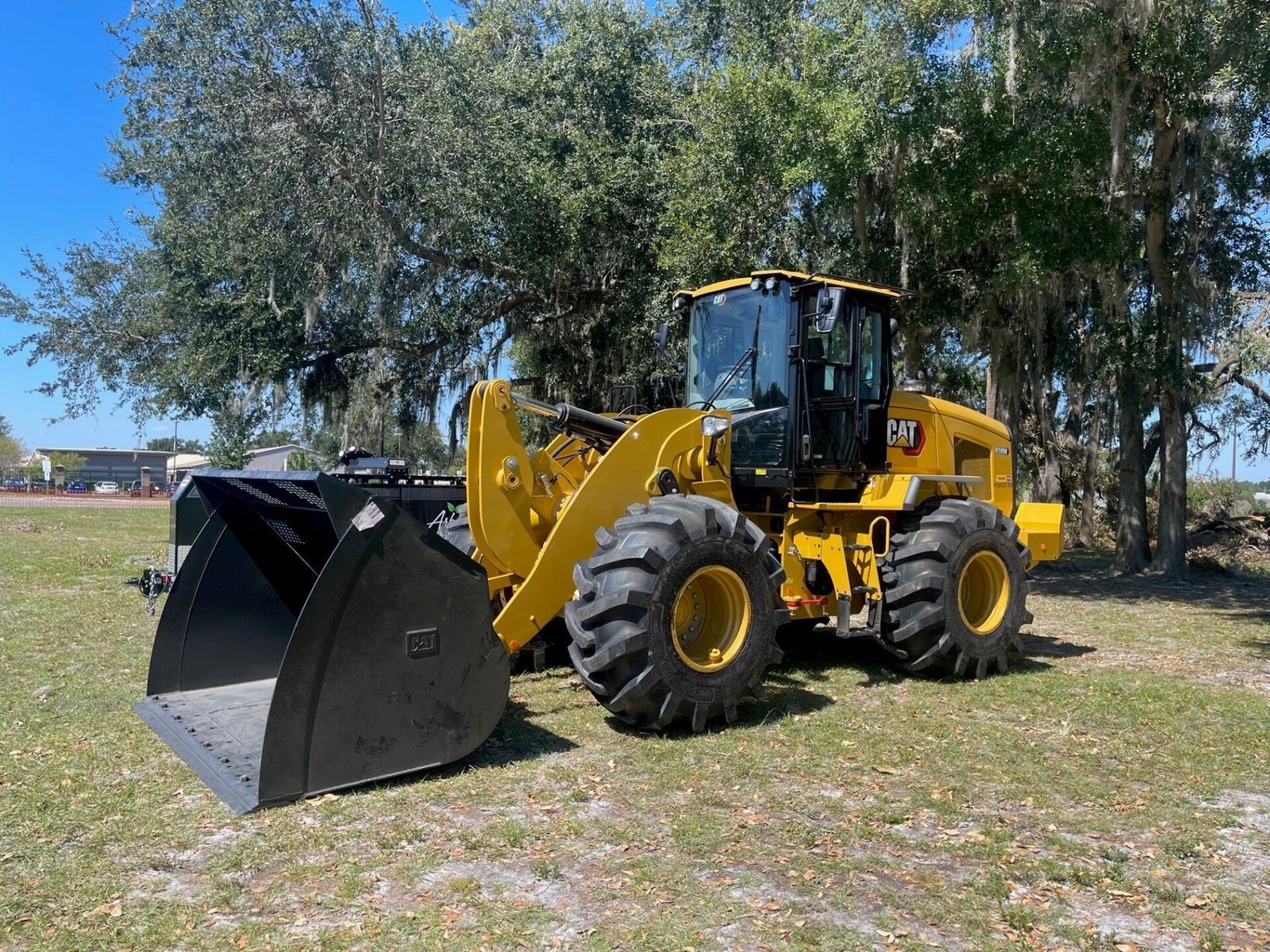 Yellow Caterpillar wheel loader on grass.