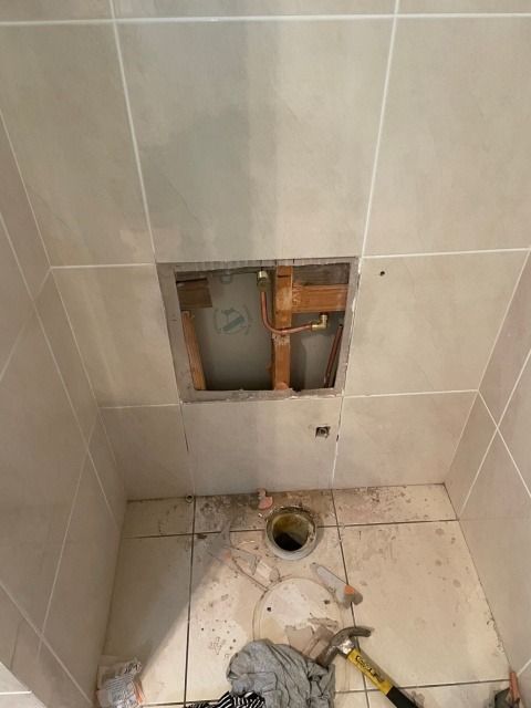 Bathroom With Damaged Ceiling Tile and Exposed Plumbing Above a Toilet — Hales Plumbing & Roofing In The Range, QLD