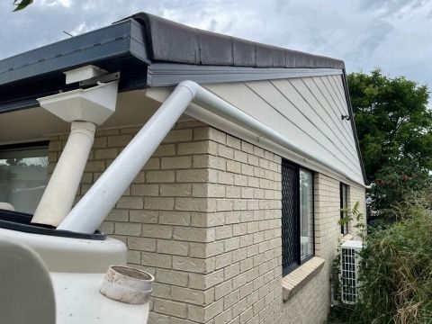 White Guttering and Downspouts on a Brick and Siding Home — Hales Plumbing & Roofing In The Range, QLD