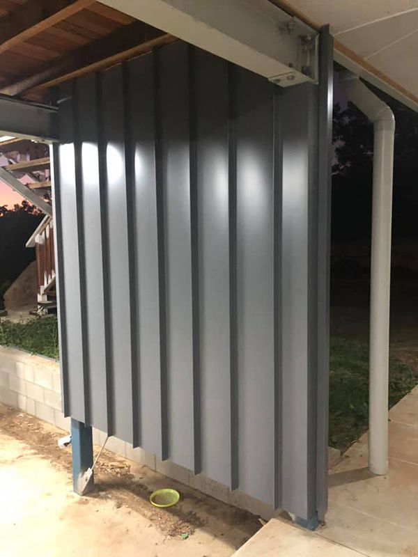 A Gray Wall Is Sitting Under A White Roof — Commercial Roofs in Toowoomba, QLD