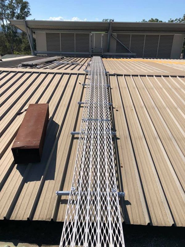 A Roof With A Metal Walkway Leading To A Building — Commercial Roofs in Toowoomba, QLD