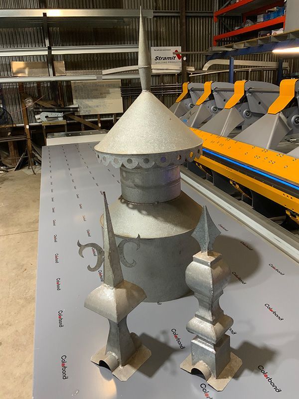 A Metal Sculpture Is Placed On A Table In A Warehouse — Roofer in Toowoomba, QLD