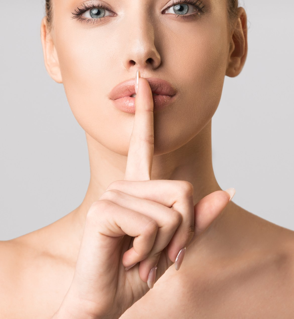 A woman is holding her finger to her mouth