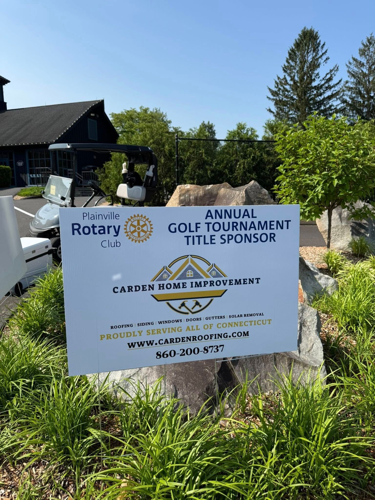 A sign that says annual golf tournament title sponsor is in front of a house.