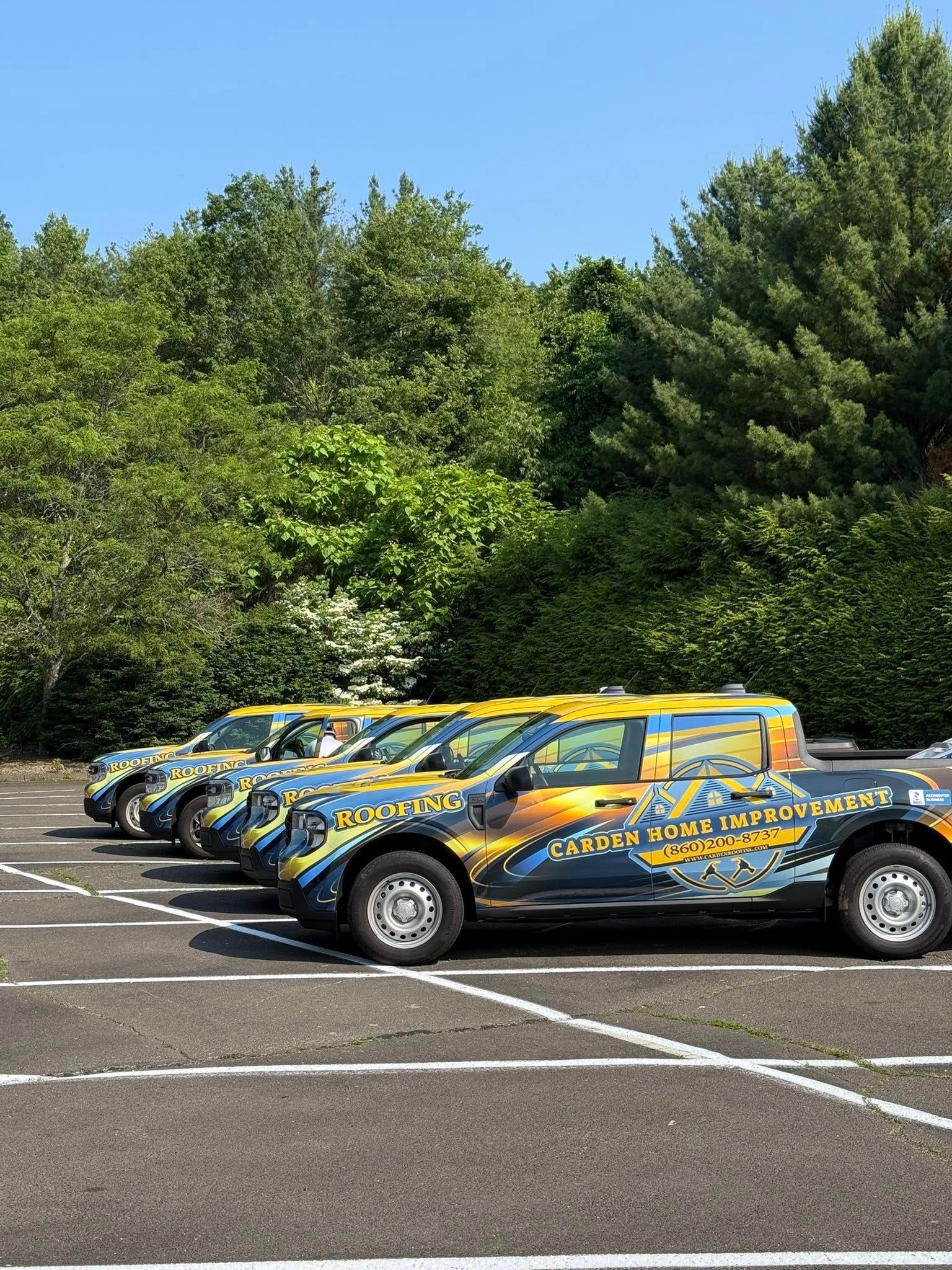A row of trucks are parked in a parking lot.