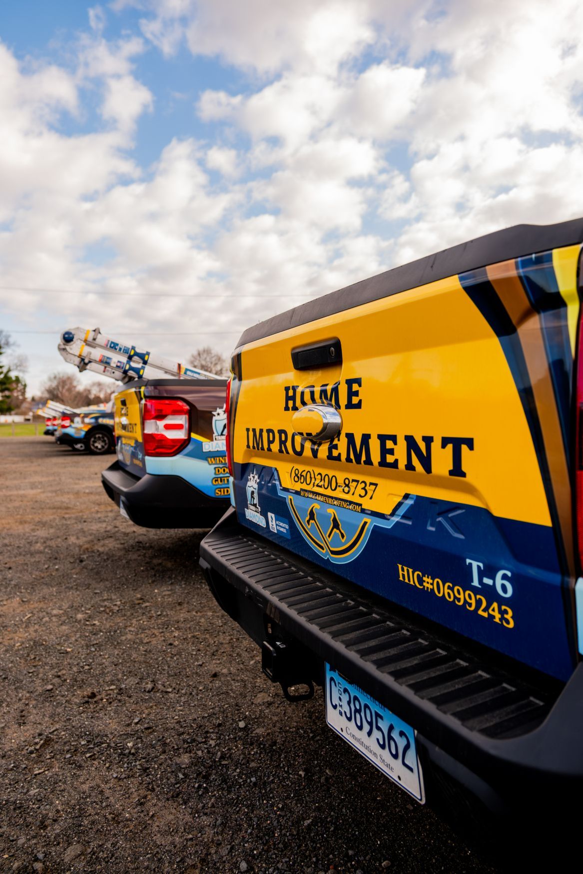 Home Improvement truck with colorful branding parked in a lot under a cloudy sky