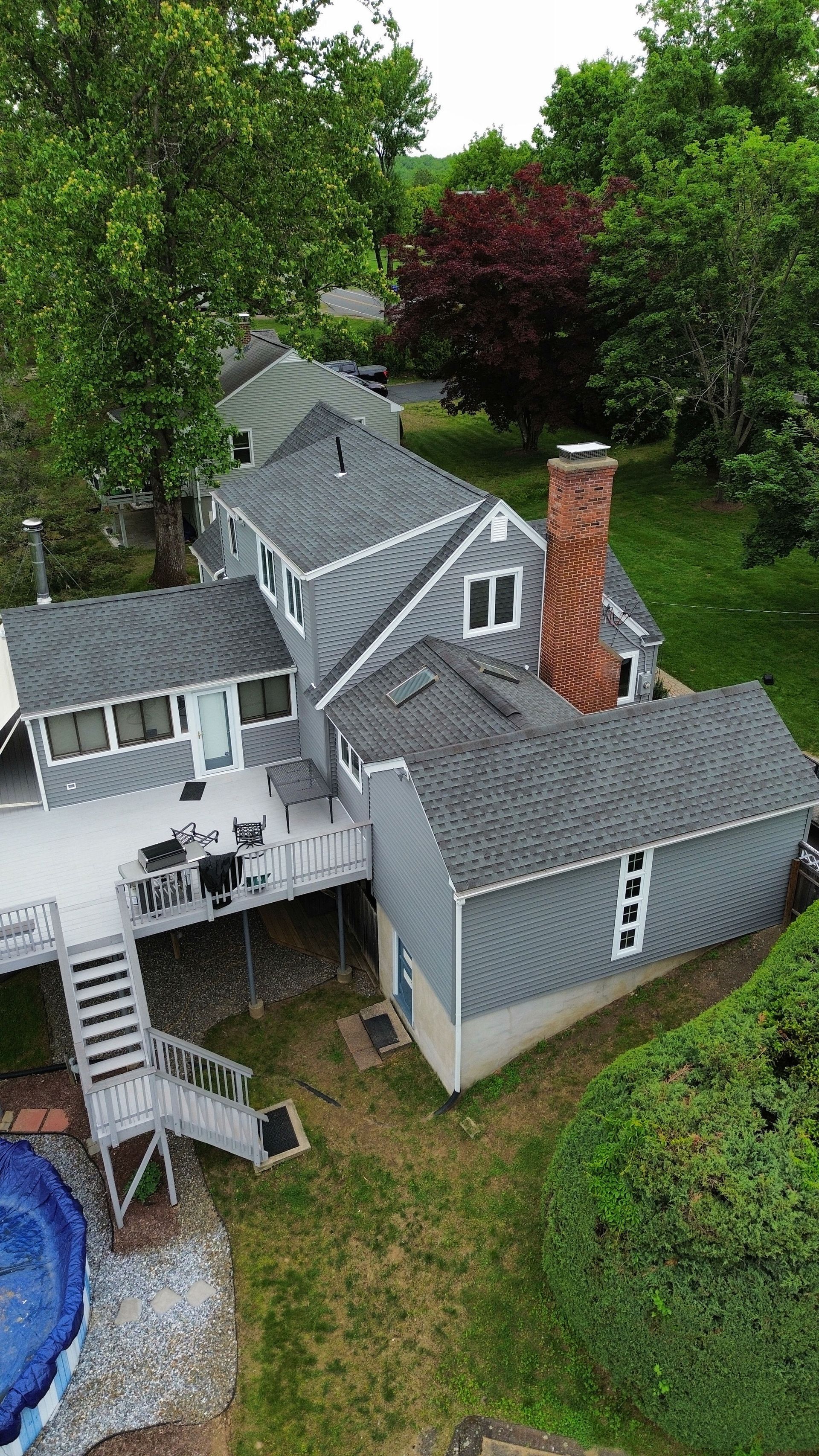 An aerial view of a white house with a brown roof.