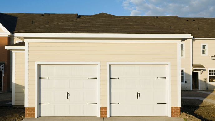 A potted plant is sitting on a window sill next to a window with a view of a park.
