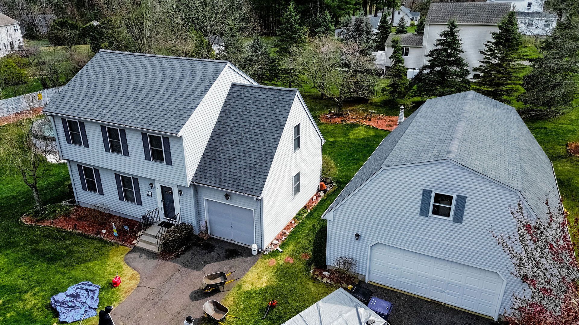 An aerial view of a white house with a garage next to it.