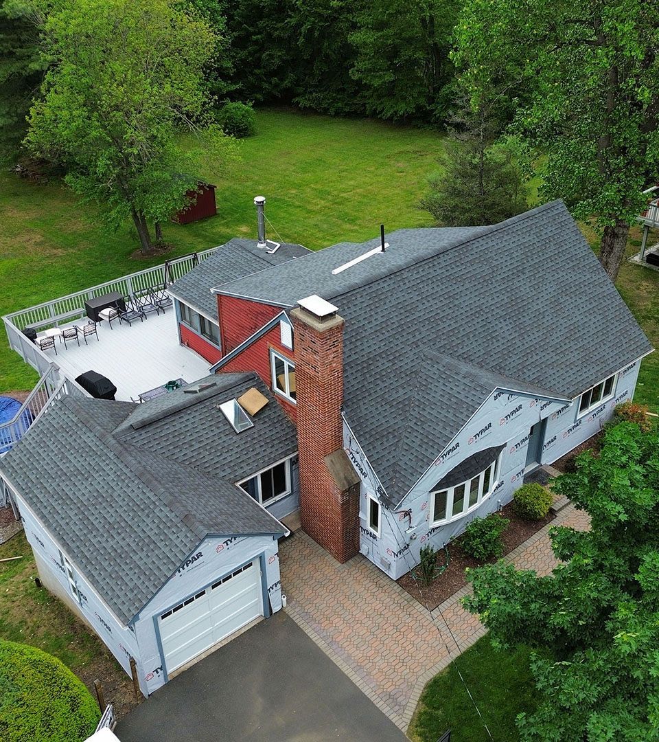 An aerial view of a house with a gray roof