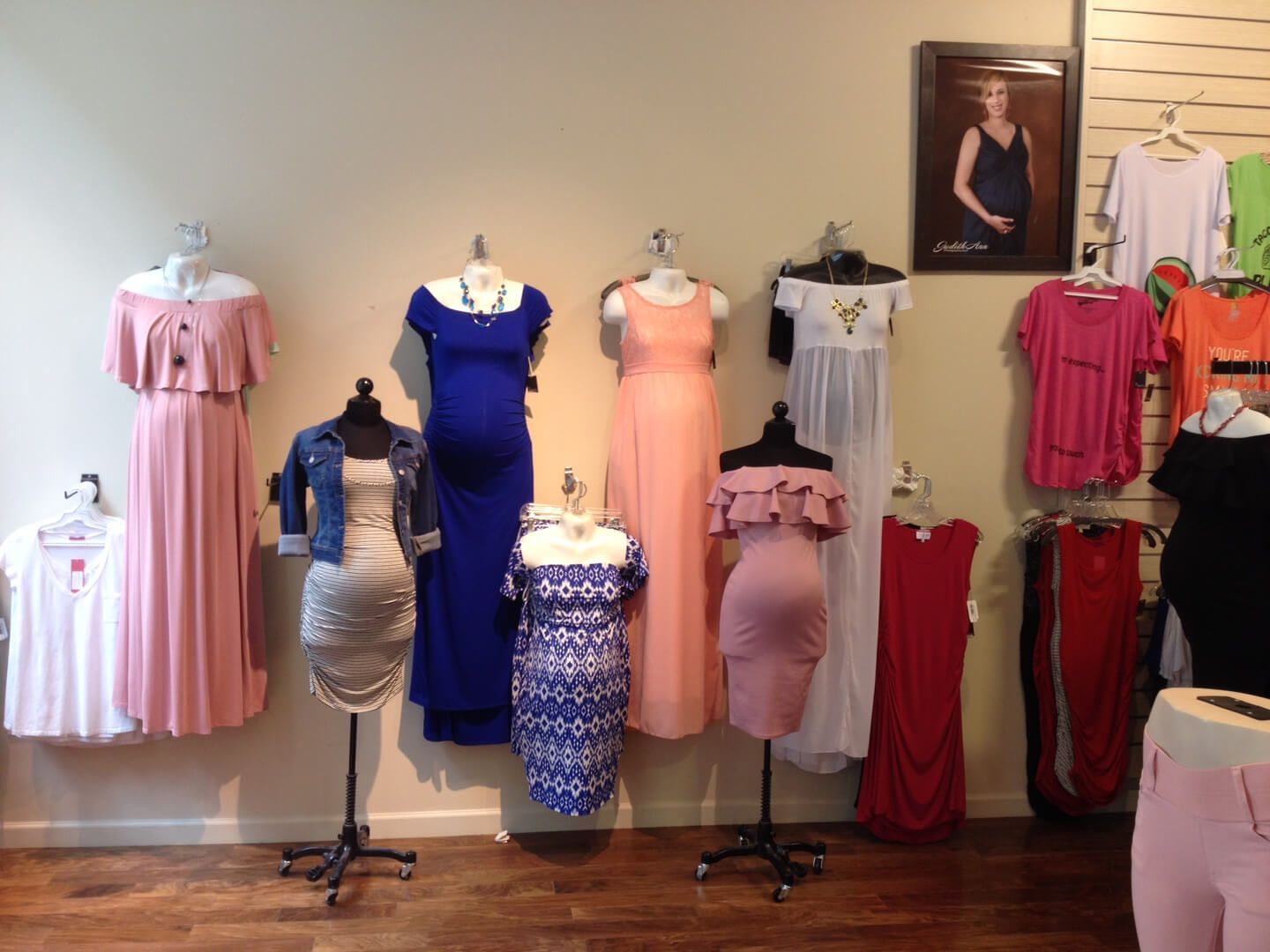 A display of maternity clothes on mannequins in a store.