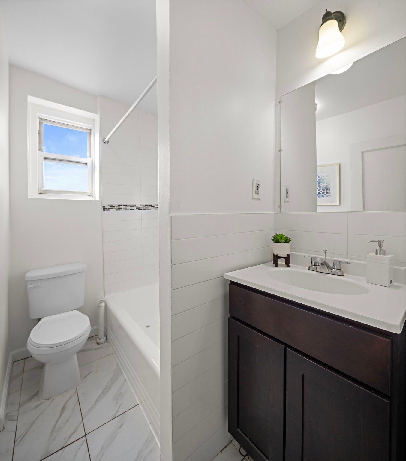 A bathroom with a toilet a sink and a window