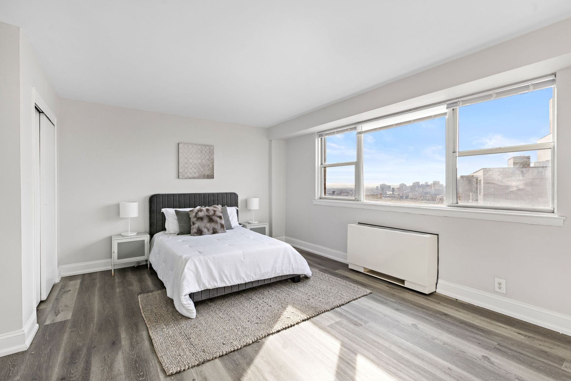 A bedroom with a large bed and a large window with nice views