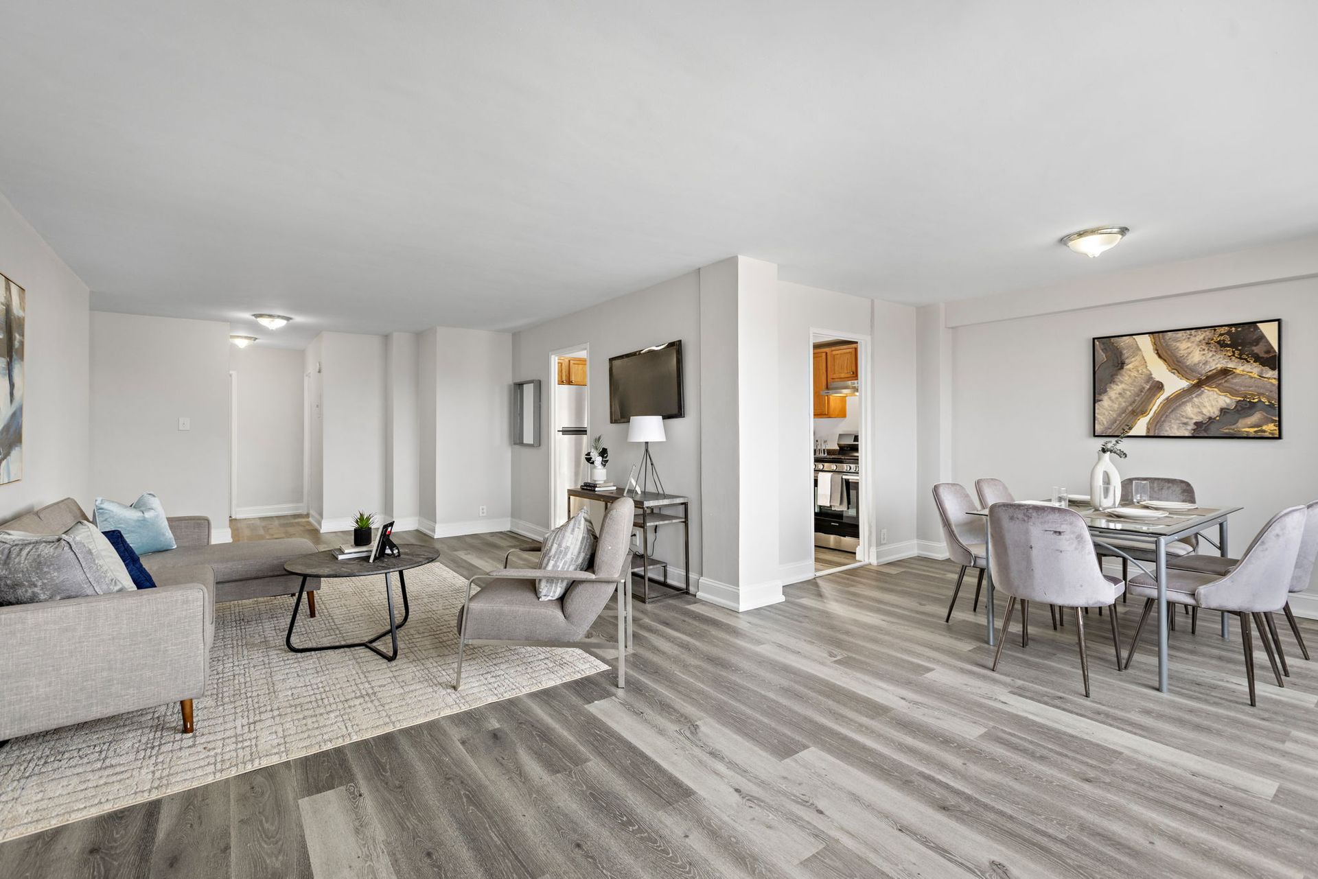 A beautiful and spacious living room with a couch and chairs and a dining room with a table and chairs.