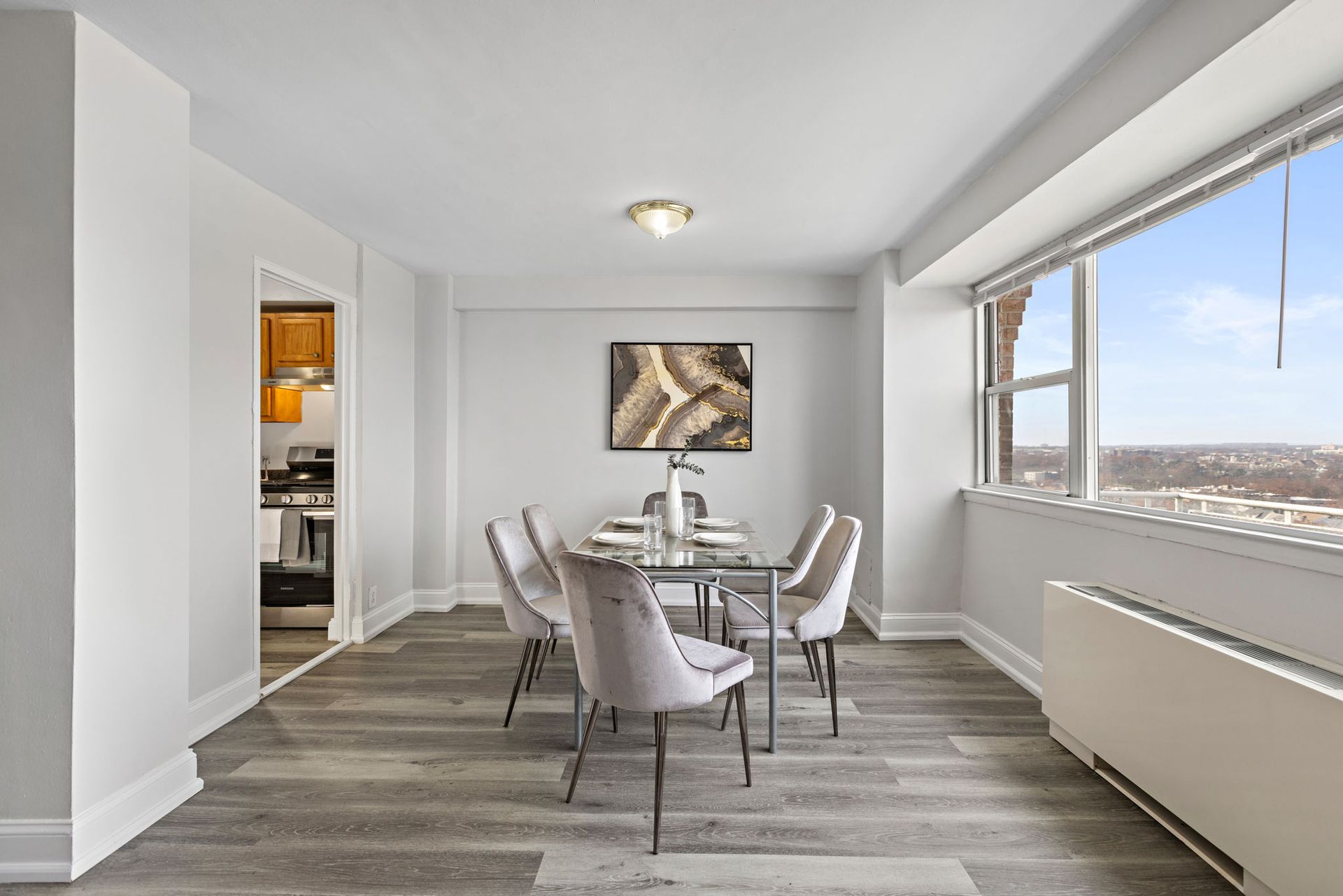 A dining room with a table and chairs and a large window with nice views