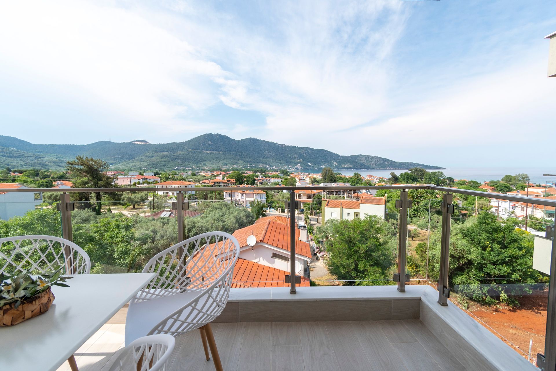 A balcony with a table and chairs overlooking a city