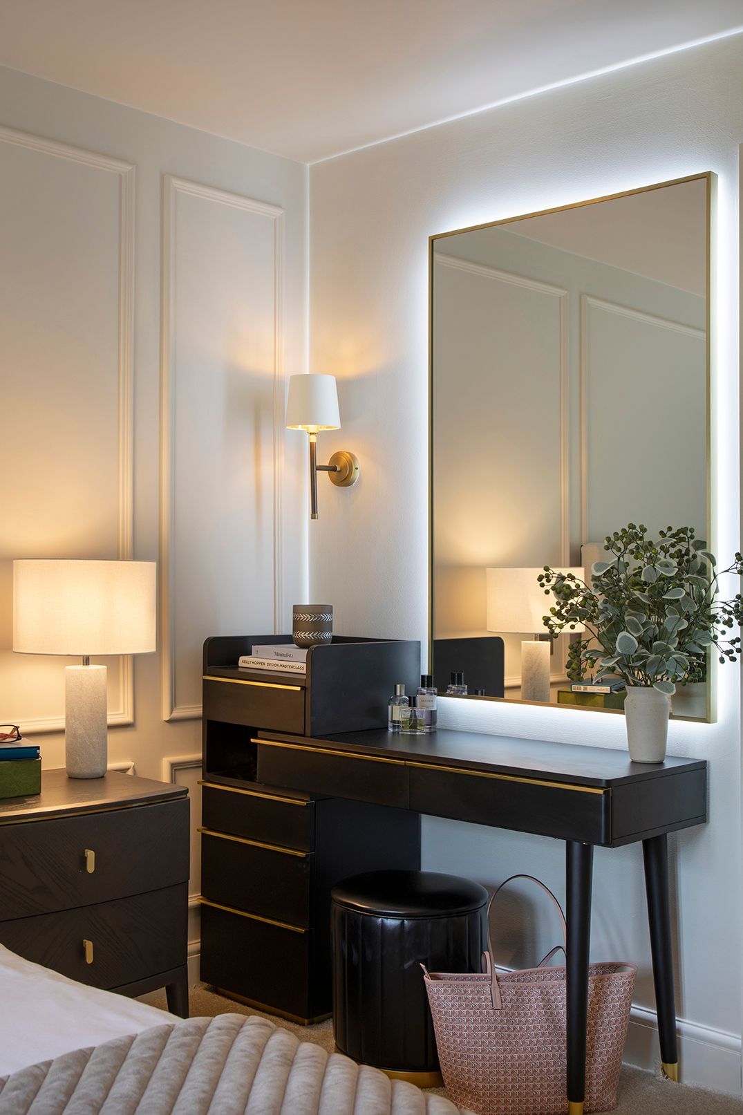 Black dressing table with LED-backlit brass mirror and velvet stool in Hertford master bedroom by Elisa Design
