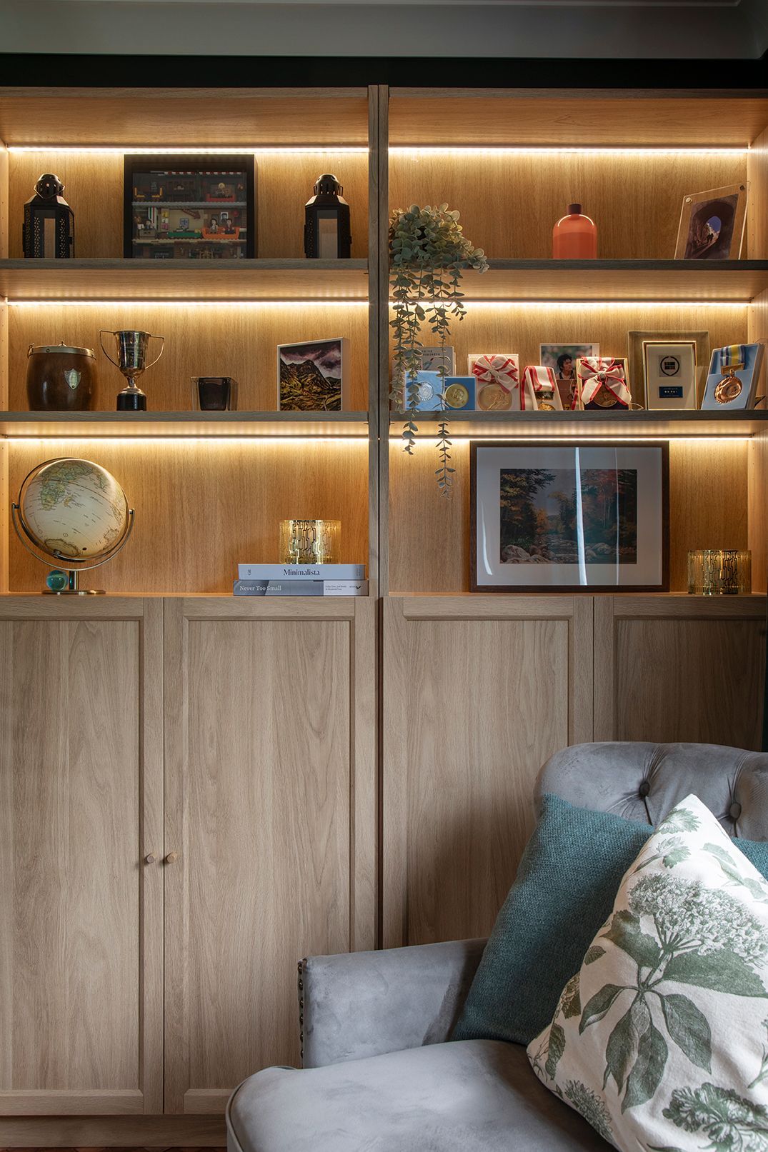 Custom LED-lit shelving and styled decor in hunter green living room - Elisa Design Welwyn Garden City